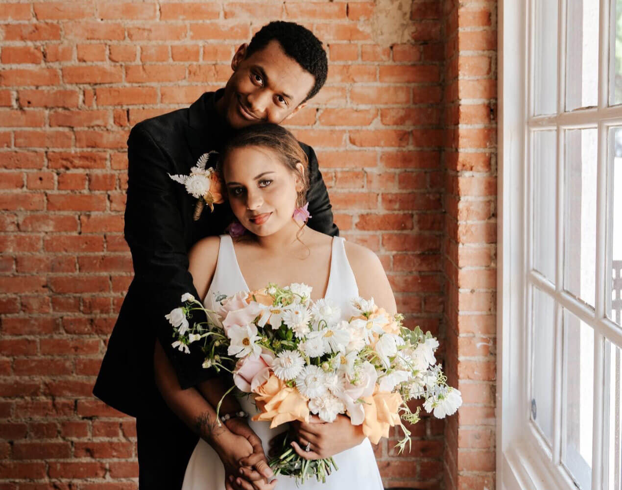 Сouple wearing a white gown and a black suit